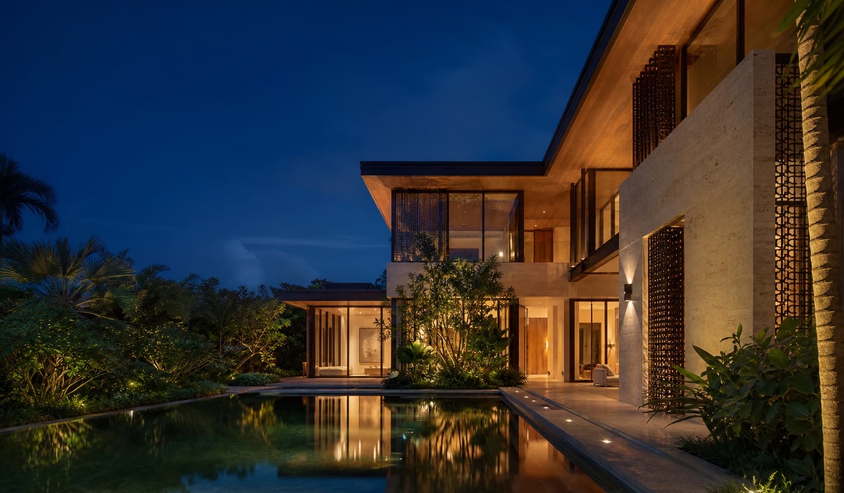 Tropical modern limestone residence glowing at blue hour in Coral Gables